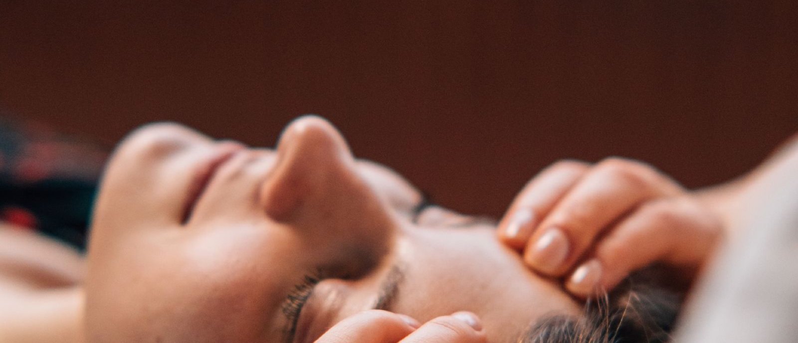A therapist working warm herbal oil through the scalp and temples during an Ayurvedic head spa at Plum & Sugar