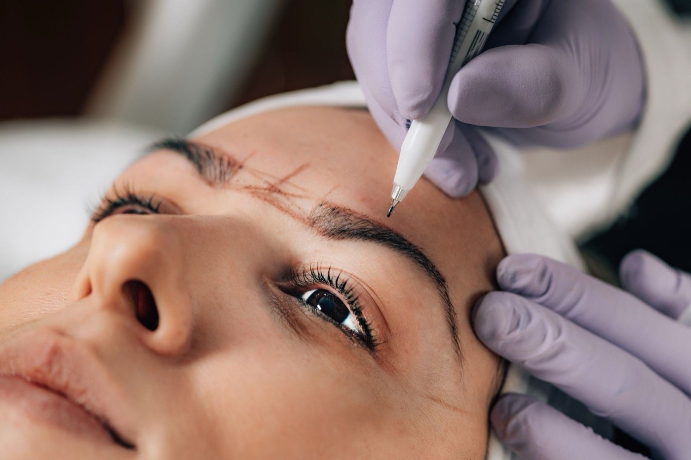 Close-up of a microblading appointment with the brow shape mapped out before pigment