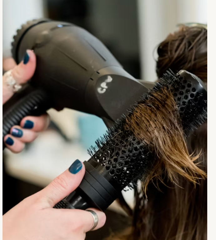 Stylist prepping a bride's hair on her wedding day at Plum & Sugar