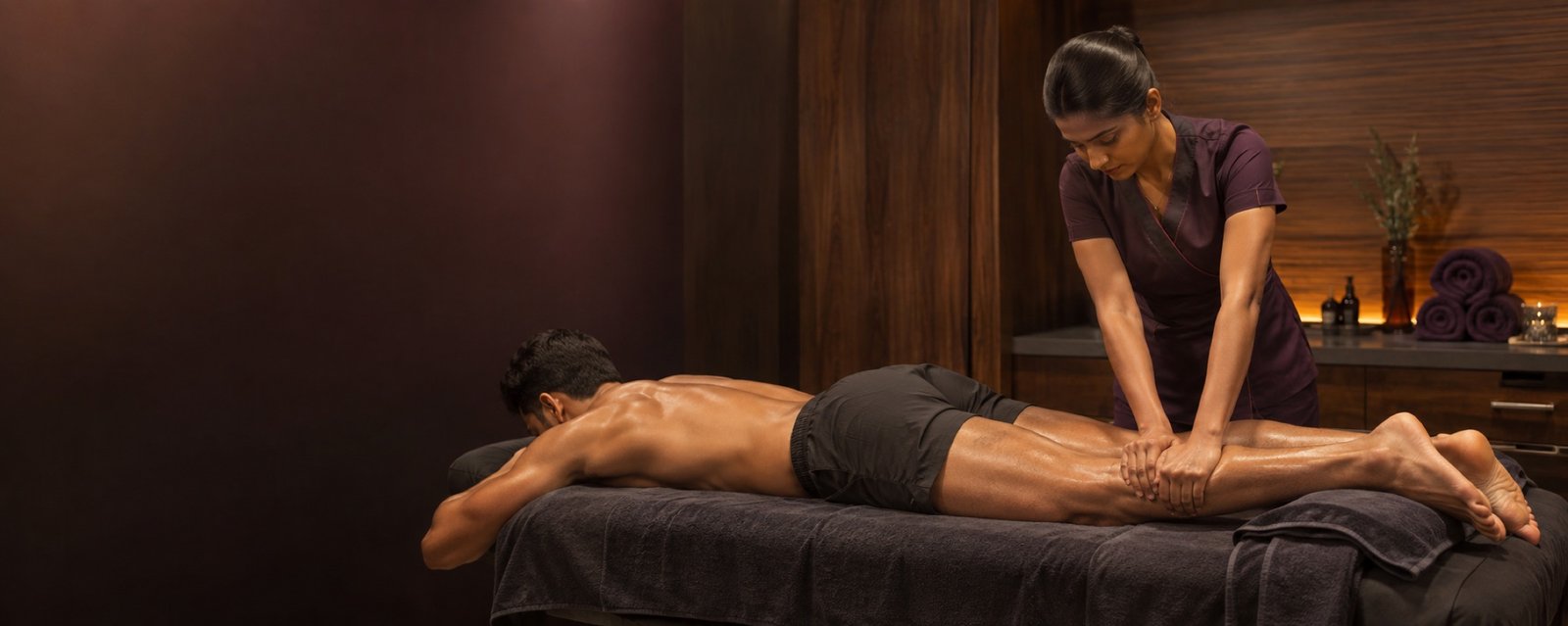 Indian sports massage therapist applying targeted calf pressure for athletic recovery